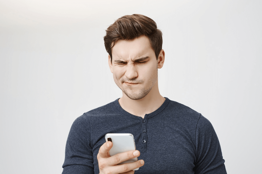 A disappointed person looking at his smartphone